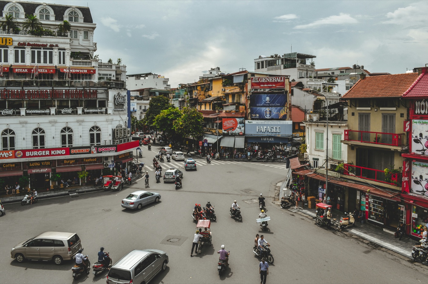A bustling Hanoi street with motorbikes, vendors and storefronts.